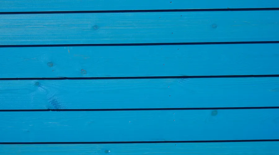 Which Brand for Your Siding Type? - Close-up of yellow painted wooden planks with a clear textured finish