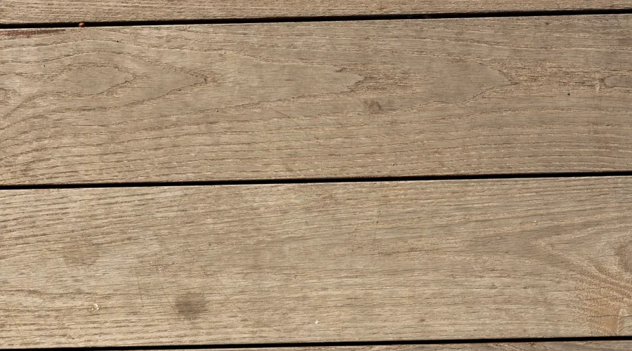 What Makes a Deck Sealer Work in Full Sun? - Close-up of rustic wooden planks forming a textured backdrop