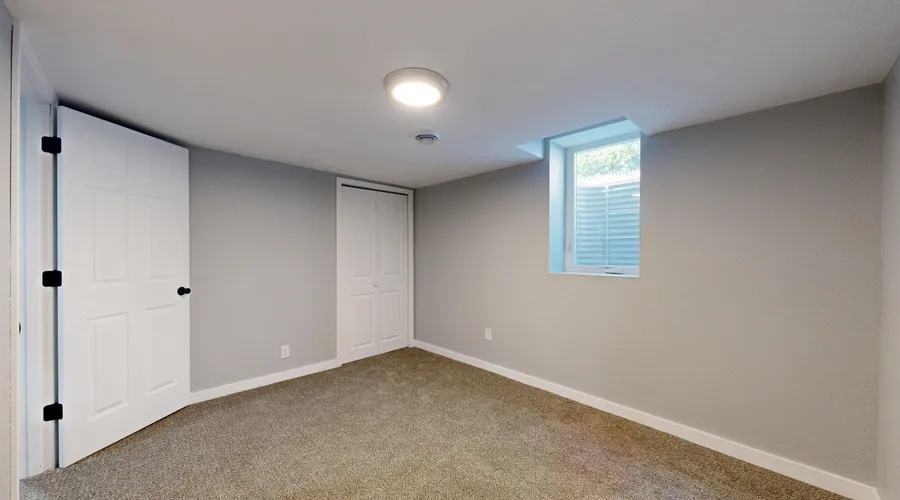 What Is Epoxy Paint? - Bright empty room with carpet flooring and natural light from window