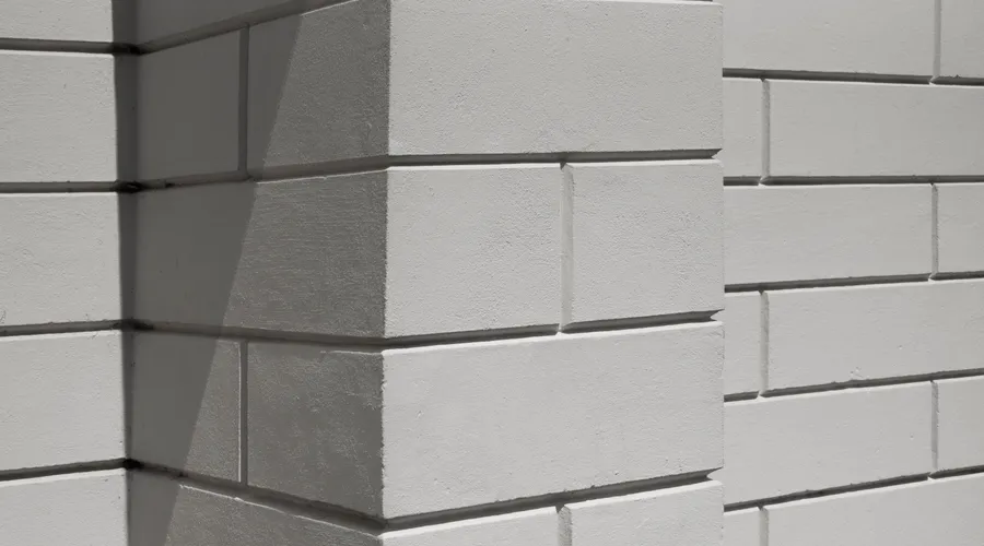 What Is Standard Masonry Paint? - Close-up of a white brick wall with geometric shadows