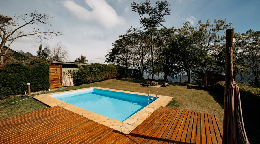 The 5 Best Sealers for Redwood Decks - Scenic outdoor swimming pool surrounded by lush greenery and wooden decking