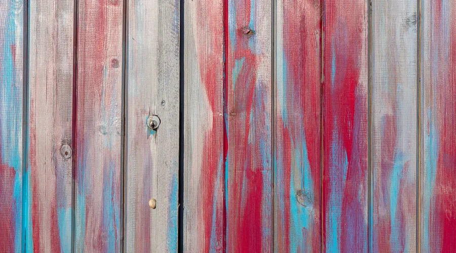 Option D: Solid Color Stains - Close-up of a colorful wooden fence with artistic red and blue paint strokes