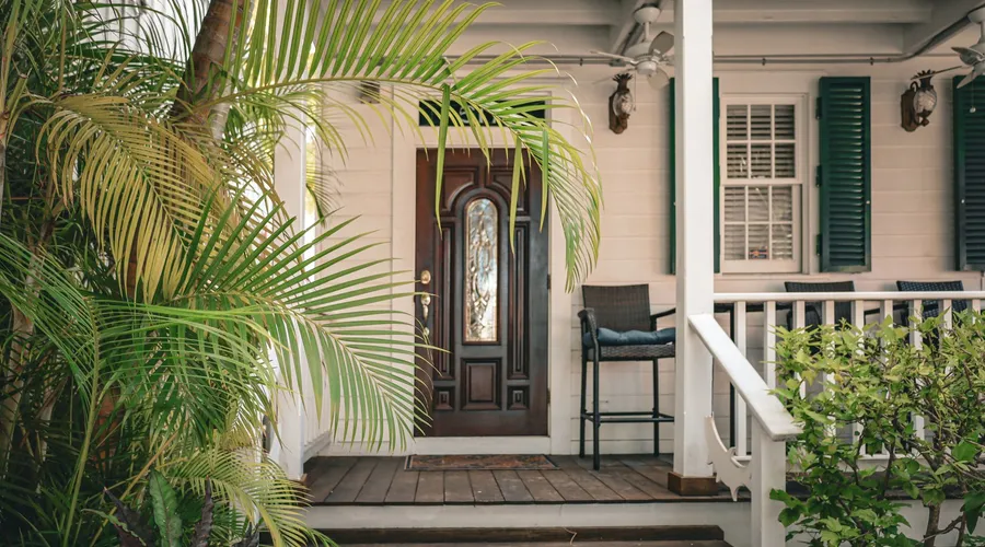 What Is Exterior Acrylic Latex Paint? - Colonial house entrance with tropical plants and wooden door