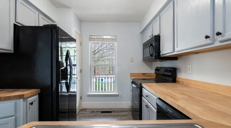 What Is Tricorn Black SW 6258? - Bright and spacious kitchen featuring modern design with wooden countertops and stainless steel appliances