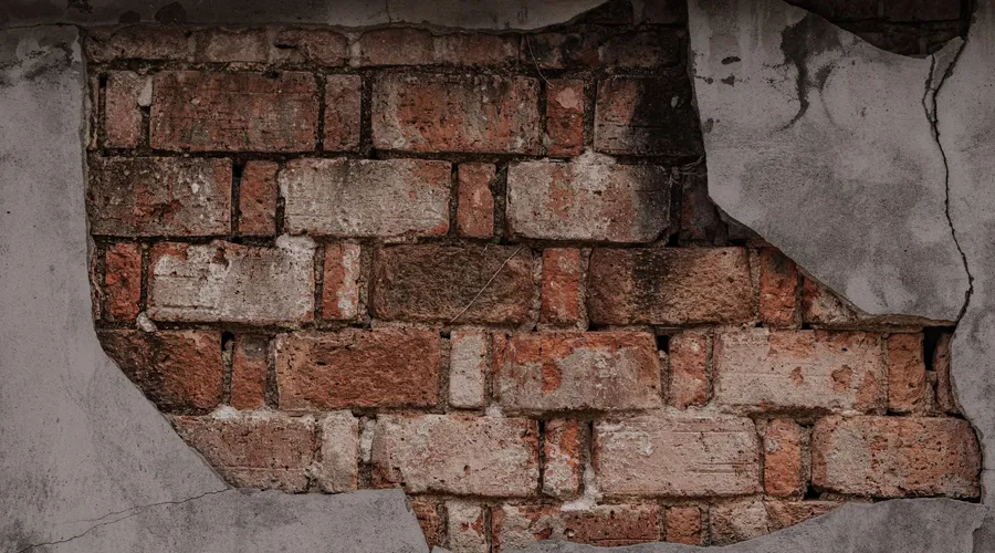 Head-to-Head: 6 Key Differences - Close-up of a weathered wall with exposed rustic brickwork