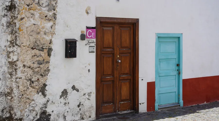 Quick Comparison - Weathered urban wall features contrasting wooden and turquoise doors with vintage textures