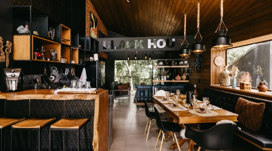 What Is Tricorn Black (SW 6258)? - Cozy indoor dining area with modern kitchen and rustic decor in Espírito Santo